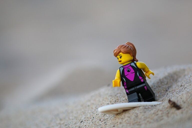 Lego minigugure, with a surfboard in sand